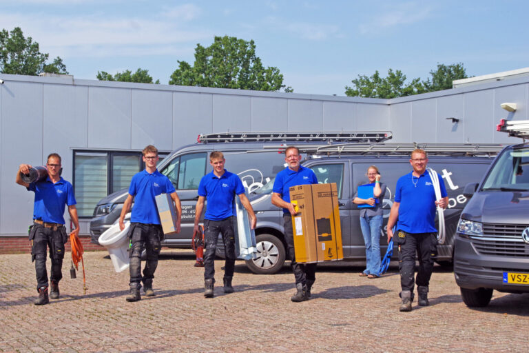 Team van installateurs van PBuist in blauwe bedrijfskleding met gereedschap en apparatuur voor bedrijfsbusjes bij het bedrijfspand