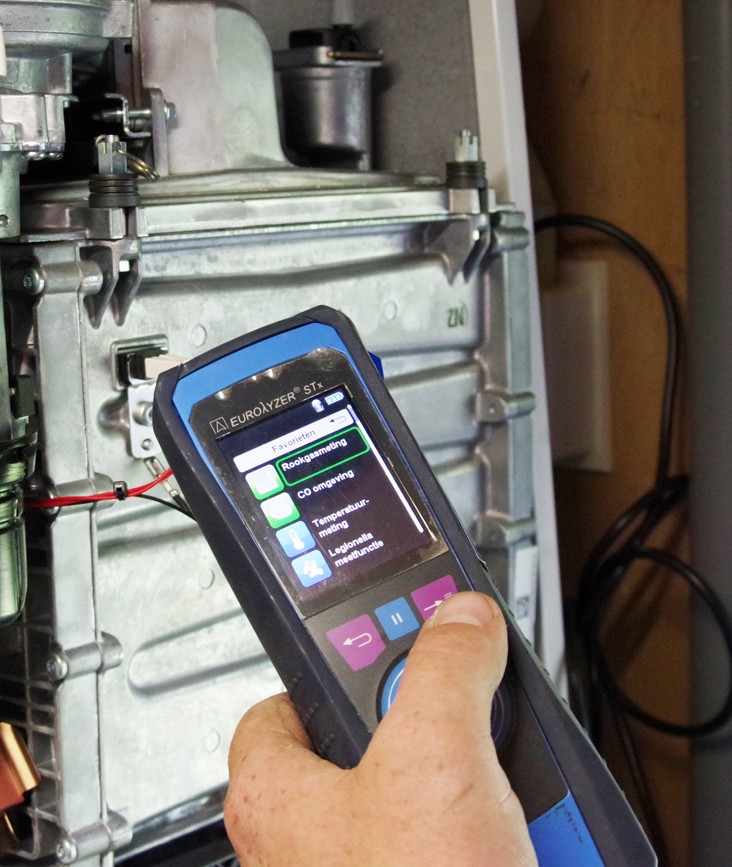 Handmeter meet rookgas bij verwarmingsketel